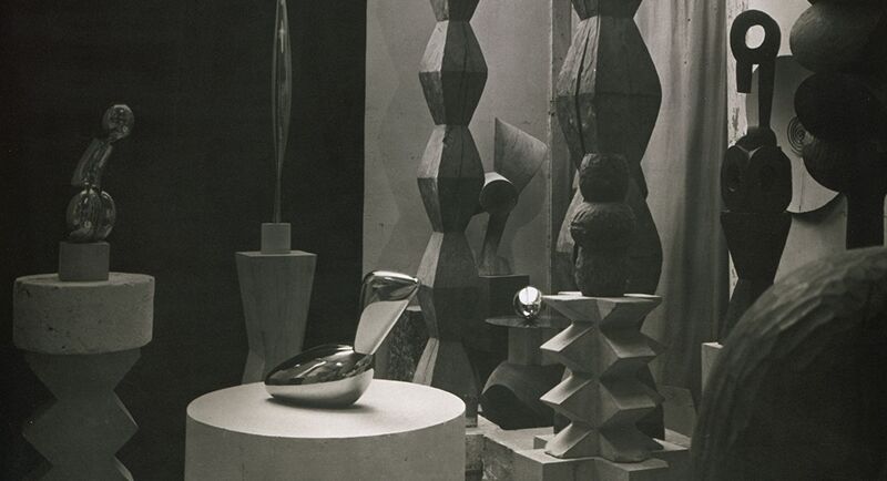 Constantin Brancusi. View of the studio: Princess X (1915–16), Bird in Space (1927, bronze), Leda (1926), Endless Columns I–III (1925, 1926, and c. 1928), Exotic Plant (1923–24). c. 1929. Gelatin silver print, 11 3/4 × 9 3/ (29.8 × 23.8 cm). Centre Pompidou, Paris, Musée national d’art moderne-Centre de création industrielle, Constantin Brancusi Bequest, 1957. PH 79 A. Digital Image © CNAC/MNAM, Dist. RMN-Grand Palais / Art Resource, NY. © Succession Brancusi – All rights reserved (Adagp) 2026